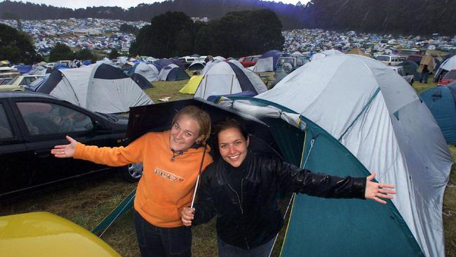 2001: Lauren and Simone camp take shelter from the rain along with hundreds of other festival goers. Picture: HWT Image Library.