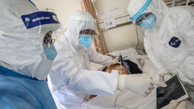 Doctors at the Wuhan Red Cross Hospital check a patient for the COVID-19 coronavirus. Picture: AFP