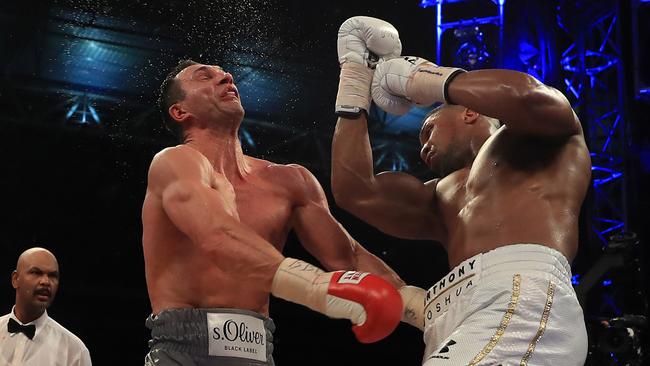 Anthony Joshua, right, lands a decisive uppercut in round 11. Picture: Getty