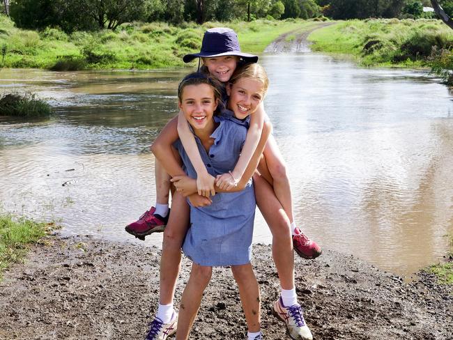 Sophie McMaster, Lucy Doolin (back) and Annabel McMaster are confronted with another flooded road on their way to school.