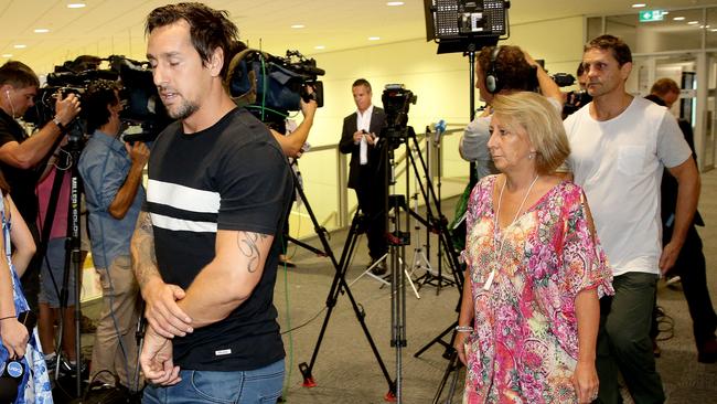 Pearce returning from Thailand with meet his parents Terri and Wayne — and the media.