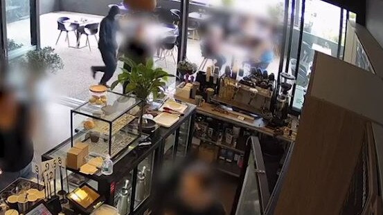 Footage captured on CCTV at Flow Cafe in Dakabin shows a masked person running straight past dining customers following an alleged armed robbery nearby. PICTURE: Flow Cafe