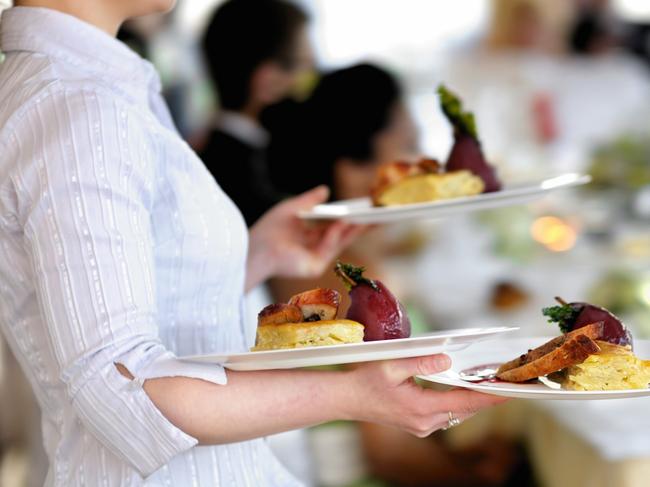 Waitress carrying three plates with meat dishGeneric photo of woman working in hospitality industry