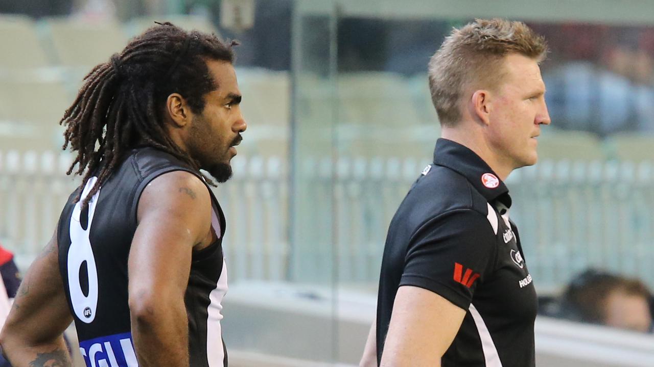 Heritier Lumumba and Nathan Buckley take in a Magpies game from the bench.