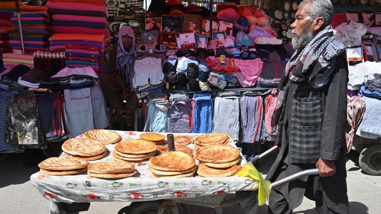 A man selling bread looks for customers while pushing a wheelbarrow cart in Kabul. Picture: Adek Berry/AFP