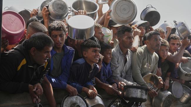 Palestinians struggle to obtain donated food at a community kitchen in Khan Younis. AP /Abdel Kareem Hana