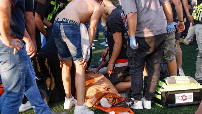 Israeli security forces and medics treat a casualty as local residents gather at a site where a reported strike from Lebanon fell in Majdal Shams village in the Israeli-annexed Golan area on July 27, 2024. Picture: Jalaa Marey / AFP