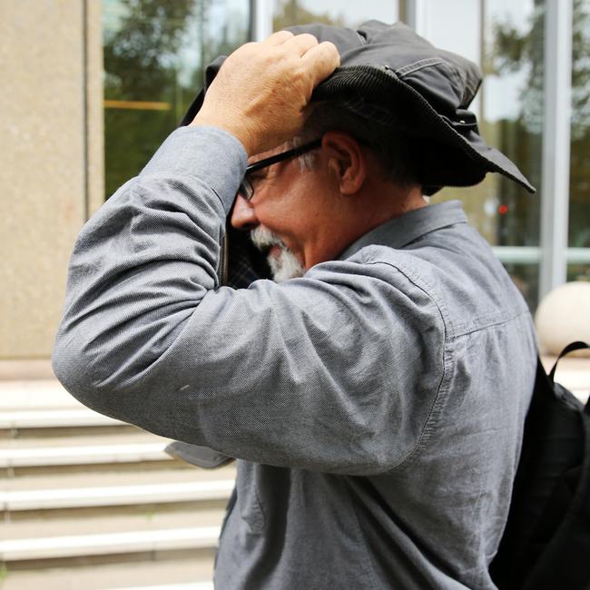 Mario Henry Aliverti attempting to cover his face at a previous hearing