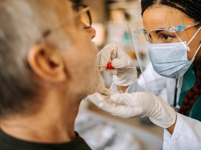 A nurse taking a swab test from a patient during a home visit.