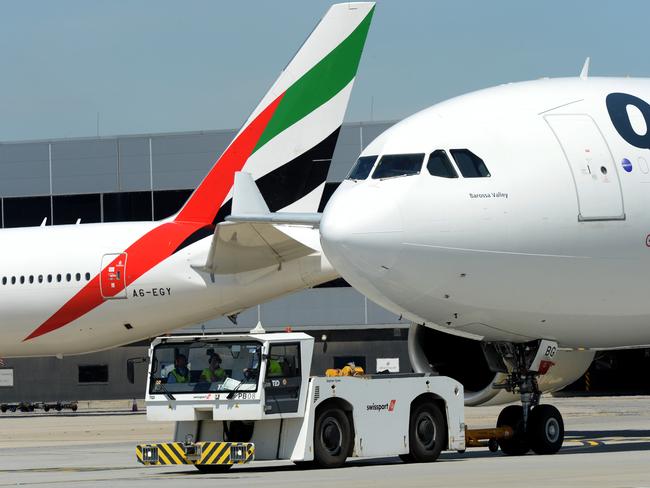 MELBOURNE, AUSTRALIA - NewsWire Photos NOVEMBER 22, 2021: A QANTAS and an Emirates plane taxi past each other at Melbourne Airport. Picture: NCA NewsWire / Andrew Henshaw