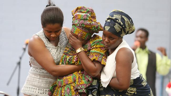 A woman is supported during the service for two young boys who drowned at Glenelg on New Year’s Day. Picture: Stephen Laffer