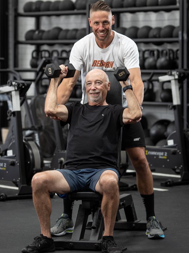 Personal trainer and gym manager Pat Carr helps his dad Maurice work out. Picture: Julian Andrews