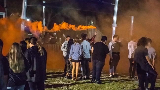 One partygoer lets off a smoke bomb on the foreshore. Picture: Jason Edwards