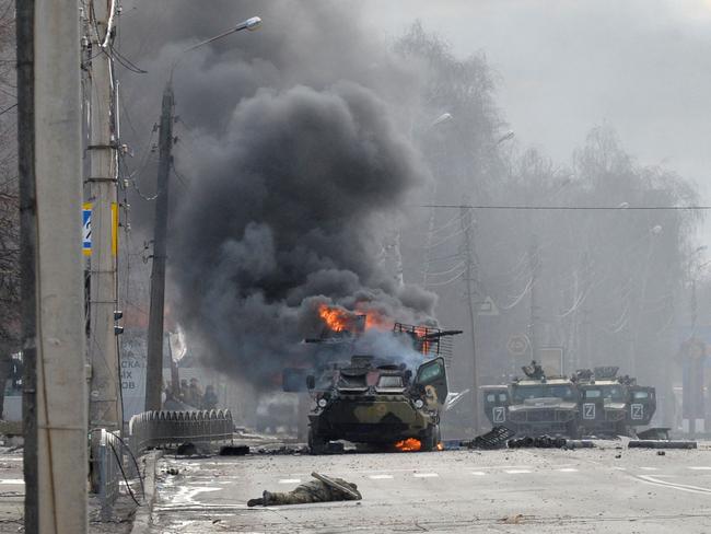 A Russian armoured personnel carrier (APC) burning next to unidentified soldier's body during fight with the Ukrainian armed forces in Kharkiv. Picture: AFP