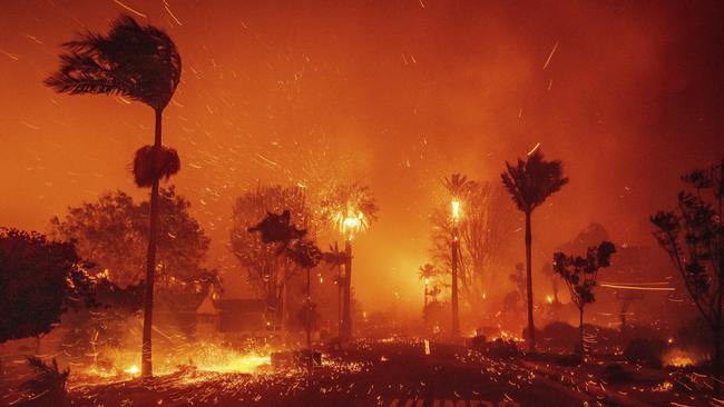 The Palisades Fire ravages a neighborhood amid high winds in the Pacific Palisades neighborhood of Los Angeles, Tuesday, Jan. 7, 2025. (AP Photo/Ethan Swope)