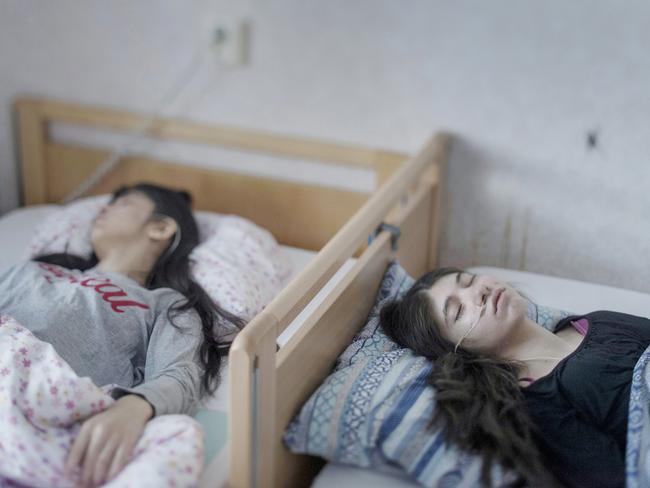 Djeneta (right) has been bedridden and unresponsive for two and a half years, and her sister Ibadeta for more than six months, with uppgivenhetssyndrom (resignation syndrome), in Horndal, Sweden. It is a condition believed to exist only amongst refugees in Sweden. Picture: Magnus Wennman/Aftonbladet/World Press Photo