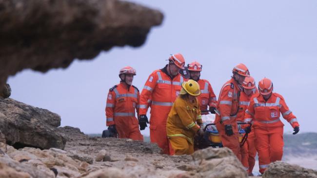 An emergency crew carries the injured woman along the beach at Torquay. Picture: Shaun Viljoen