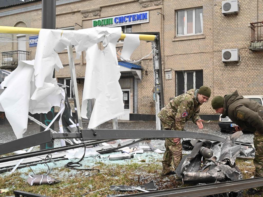 Police and security personnel inspect the remains of a shell in a street in Kyiv. Picture: AFP