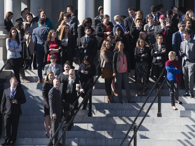 White House staffers stand on the steps of the Eisenhower Executive Office Building as they await the arrival of US President-elect Donald Trump. Picture: AFP PHOTO / SAUL LOEB