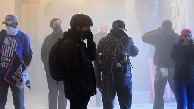 Supporters of Donald Trump enter the US Capitol as tear gas fills the corridor. Picture: AFP.