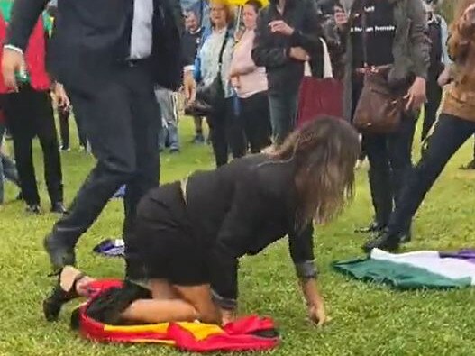 Lidia Thorpe has been forced to the ground by police and protesters after she tried to disrupt British trans critic Kellie-Jay Keen-Minshull's speech at the Let Women Speak rally outside Parliament House on Thursday. Draped in an Aboriginal flag, the bizarre vision showed Ms Thorpe crawling on the ground as police tried to help her up before eventually walking back to a group of counter-protesters. Picture: Twitter