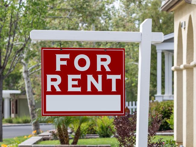 Red For Rent Real Estate Sign in Front House.