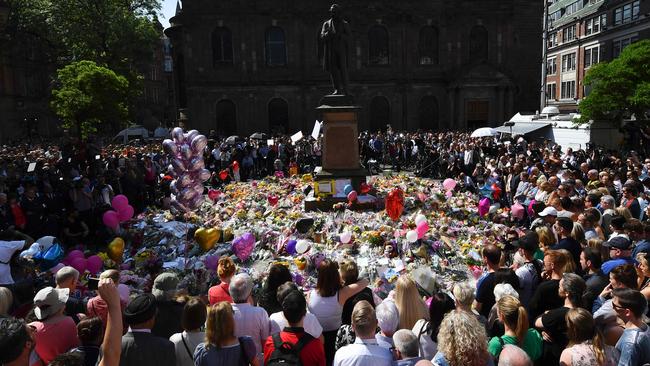 People stop to observe a minute's silence in St Ann's Square as a mark of respect to the victims of the May 22 terror attack at the Manchester Arena. Picture: AFP.