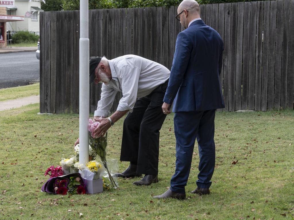 Graham Stewart lays flowers at Chinchilla Police Station in memory of fallen officers, consoled by Qld Police Union Vice President Shane Prior. Tuesday, December 13, 2022. Picture: Nev Madsen.