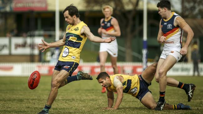 Eagle Chris Hall kicks away as Adelaide's Mitch McGovern bumps Jared Petrenko. Picture: MIKE BURTON/AAP