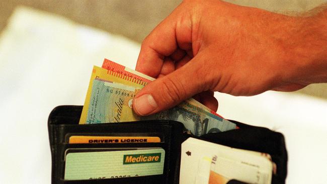 Mar 03, 2000 : Generic photo of man removing money from his wallet - notes Australian currency hand medicare card