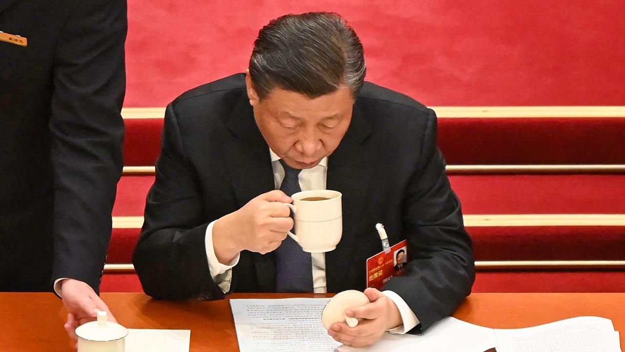 China's President Xi Jinping drinks a cup of tea during the second plenary session of the National People's Congress (NPC) at the Great Hall of the People in Beijing on March 7, 2023. (Photo by Greg Baker / AFP)