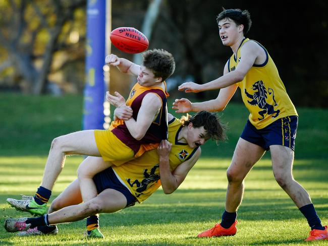 St Michael’s player Mitch Guidera gets tackled by Scotch’s Zac Becker while his teammate Lachie Francis looks on. Picture: AAP/Morgan Sette