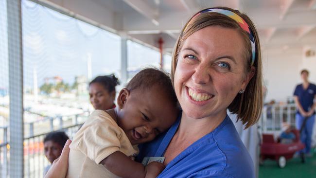 2015 Mercy Ships - Photo Credit Catrice Wulf - Ward nurse Deb Louden (AUS) holds a caregiver's child on Deck 7.