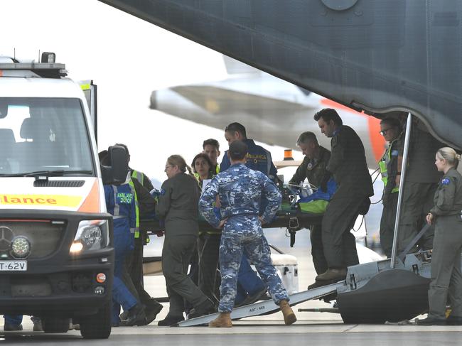 A survivor is removed on a stretcher from a RAAF C-130 Hercules at Sydney Airport. Picture: AAP