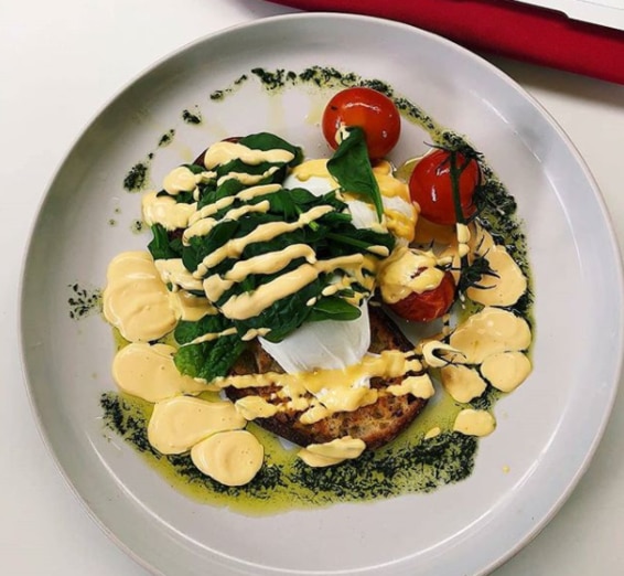 Darwins University of Queensland plates up eggs benny with free-range eggs, roasted tomatoes, spinach and sirarcha orange hollandaise. Picture: Instagram/darwinsuqu