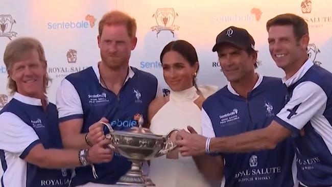 Meghan, centre, with Harry during the trophy ceremony at the Royal Salute Polo Challenge in Palm Beach, Miami.