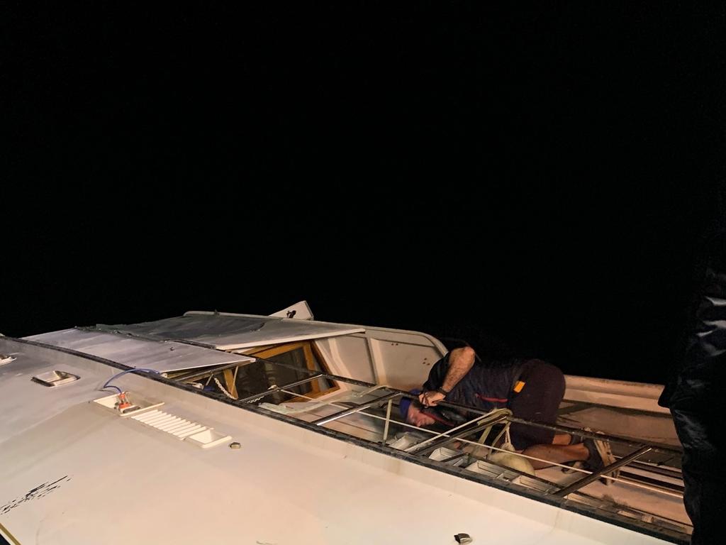 Mike Looney looking through a window for the couple’s missing dog. Picture: Marine Rescue Bribie Island 445