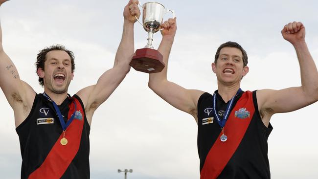 Josh Taylor with captain Daniel Porter raise the silverware for Emerald.