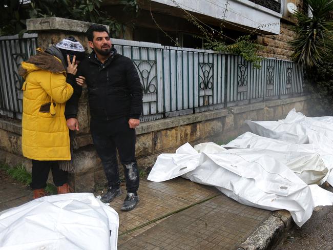 Syrians react near bodies covered with plastic lying on the street outside a morgue in the city of Aleppo. Picture: AFP