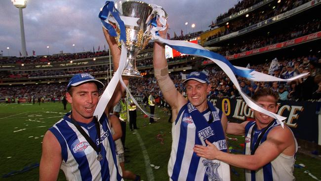 Craig Sholl and John Longmire hold the 1999 premiership trophy aloft.