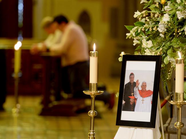 Mourners gather at St Patrick's Cathedral in East Melbourne at a picture of George Pell with Pope Benedict XVI following the overnight death of George Pell in Rome. Picture: Andrew Henshaw