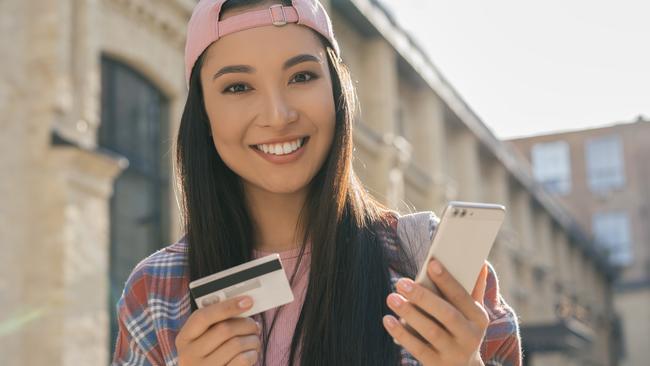 Beautiful Asian woman holding credit card shopping online