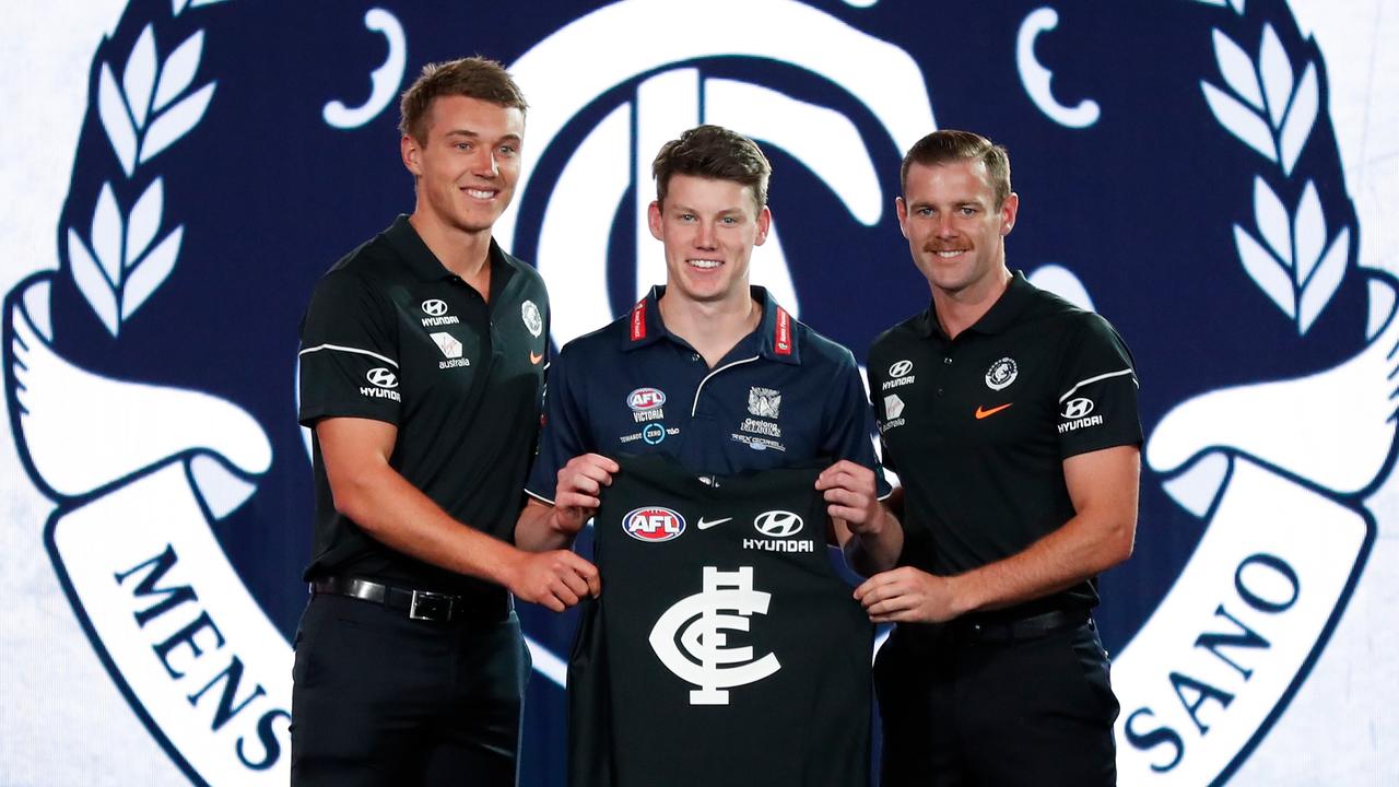 Patrick Cripps (left) hands Sam Walsh (centre) his Carlton jumper at the 2018 AFL Draft. Photo: Michael Willson/AFL Media/Getty Images.
