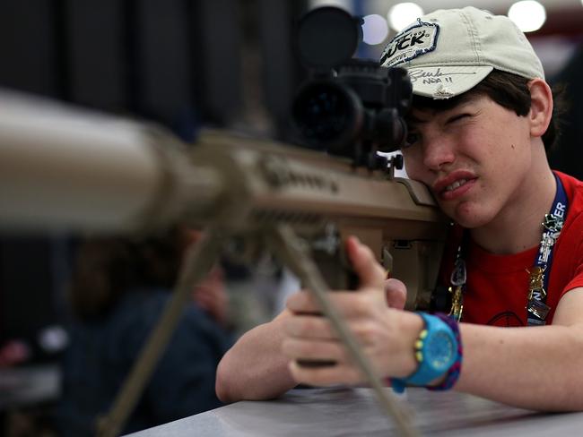 A young attendee inspects a high power sniper rifle during the NRA Annual Meeting and Exhibits in Houston, Texas. Picture: Getty/AFP