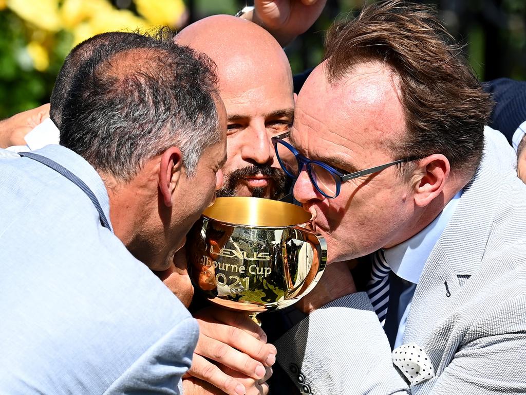 MELBOURNE, AUSTRALIA - NOVEMBER 02: Verry Elleegant owners Brae Sokolski and Ozzie Kheir with other connections, kiss the Lexus Melbourne Cup after James Mcdonald rode #4 Verry Elleegant to victory in race 7, the Lexus Melbourne Cup during 2021 Melbourne Cup Day at Flemington Racecourse on November 02, 2021 in Melbourne, Australia. (Photo by Quinn Rooney/Getty Images)