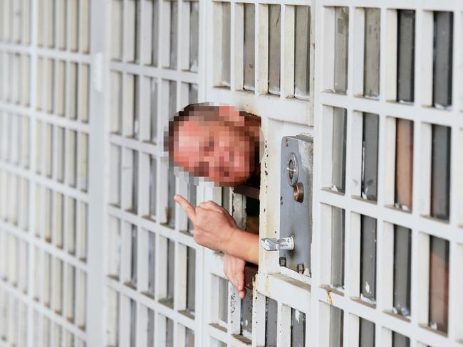 A prisoner peers through his holding cell door. Picture: Adam Taylor