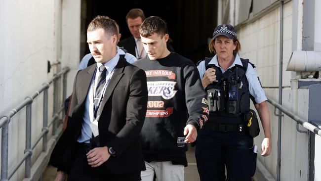 Garside is met by police at Sydney International Airport. Picture: Jonathan Ng