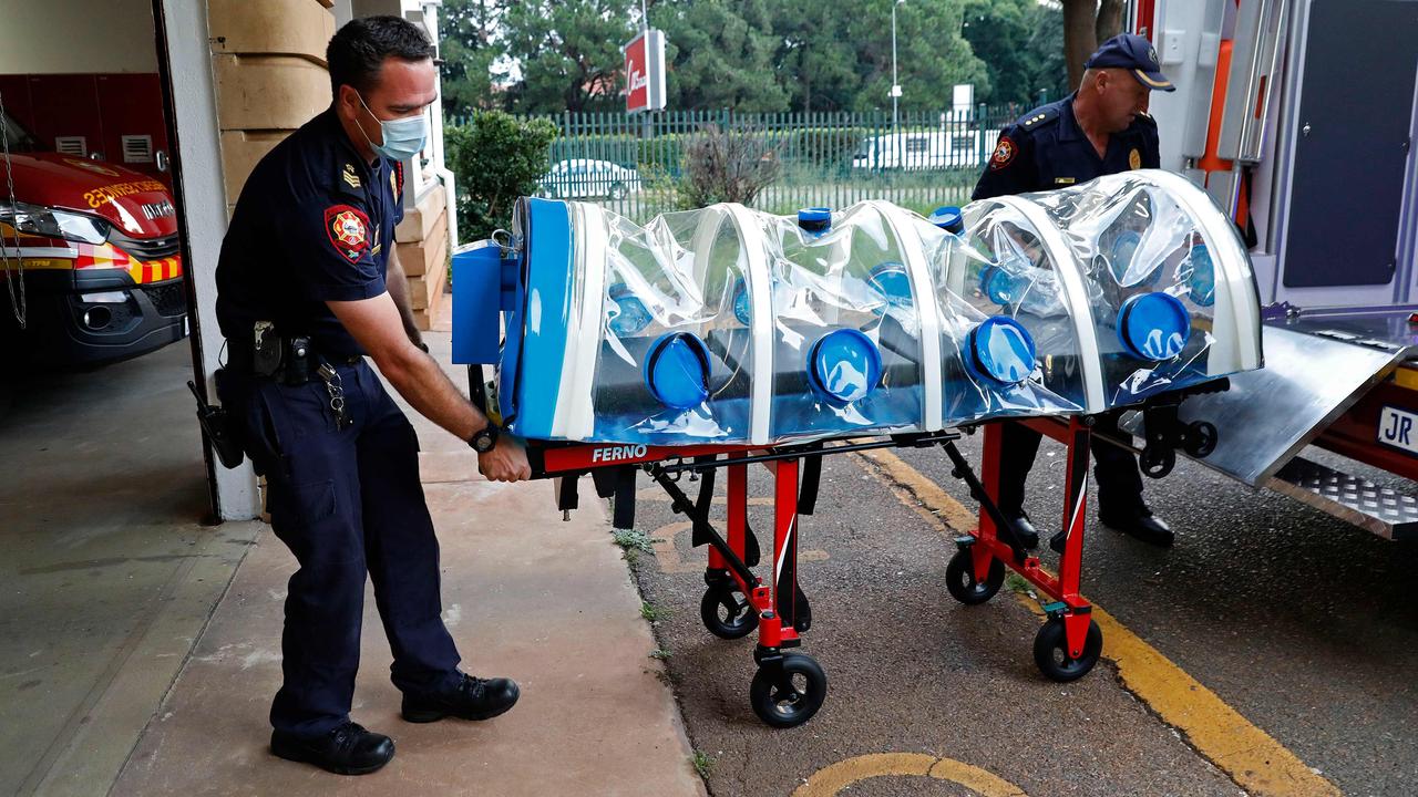 Health workers in the City of Tshwane transport a Covid-19 patient in an isolation chamber last year. Picture: Phill Magakoe/AFP