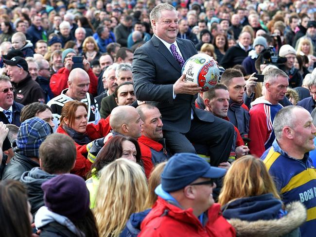 The ball is carried through the crowd before the game begins.