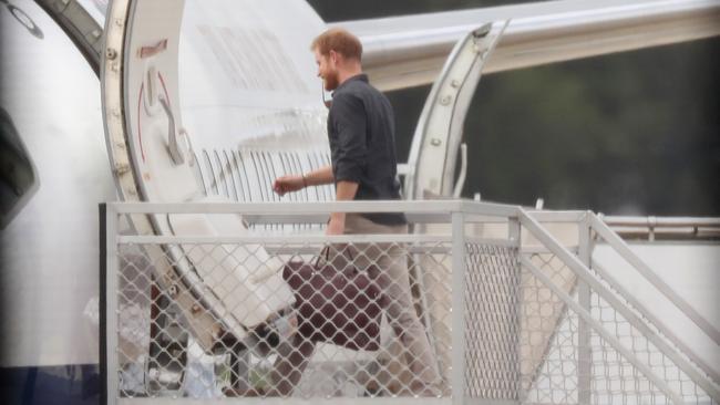 Prince Harry and Meghan Markle pictured boarding a plane at Sydney Airport this morning to fly to Fraser Island. Picture: David Swift.